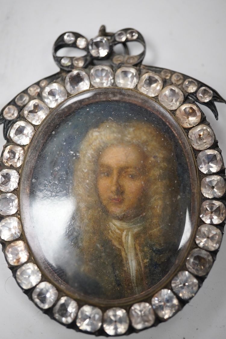 18th century, English School, Portrait of a young man wearing a wig, oil on copper, housed in an ornate jewelled frame, overall 8cm high